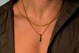 man wearing gold chains with pendant